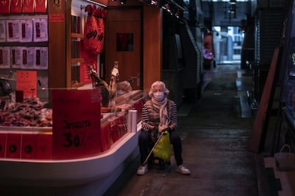 Una mujer espera su turno para comprar en un mercado prácticamente vacío de Barcelona, este miércoles.