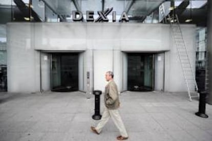 Un hombre camina delante de la sede del baco Dexia en Bruselas, Bélgica. EFE/Archivo