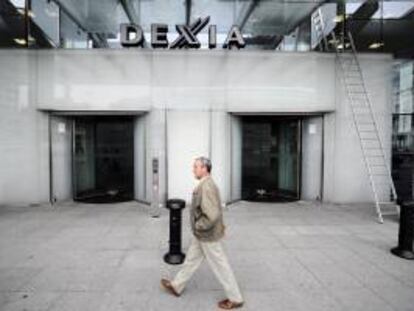 Un hombre camina delante de la sede del baco Dexia en Bruselas, Bélgica. EFE/Archivo