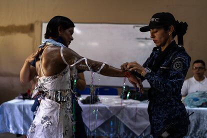 La dragoneante Angy Fuentes le ayuda a Lis Saiz, a ponerse su vestuario antes de la presentación de la obra 'El gran encuentro con la paz'.