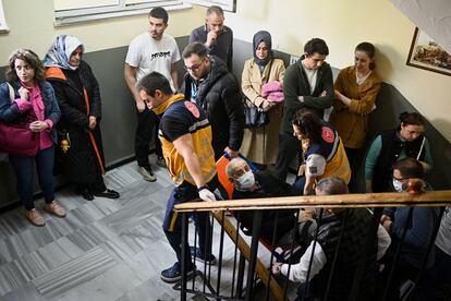 Un hombre es trasladado por sanitarios a un colegio electoral en Estambul, este domingo.