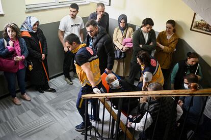 Un hombre es trasladado por sanitarios a un colegio electoral en Estambul, este domingo. 