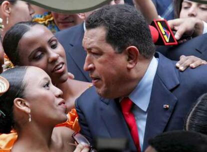 Hugo Chávez saluda a dos bailarinas durante la inauguración del centro cultural Simón Bolívar ayer en Moscú.