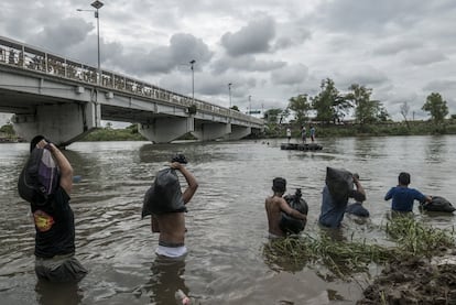 Ante la preocupación de que el caudal aumentara y tuvieran que pasar una noche más varados en Guatemala, muchos migrantes cruzaban el río con su ropa en bolsas de basura.