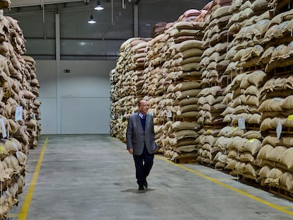 El empresario portugués Rui Nabeiro camina entre sacos de granos de café en el almacén de Delta Cafés, en 2021 en Campo Maior (Portugal).