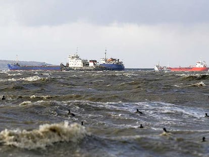 Varios barcos en medio del mar picado y con restos del vertido de combustible cerca del puerto ruso de Kavkaz, al sur de Rusia.