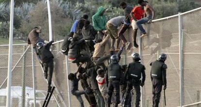 Agentes de la guardia civil junto a los inmigrantes que intentaron saltar la valla en Melilla, el 14 de octubre de 2014.