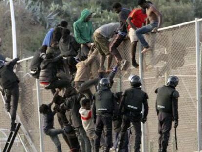 Agentes de la guardia civil junto a los inmigrantes que intentaron saltar la valla en Melilla, el 14 de octubre de 2014.