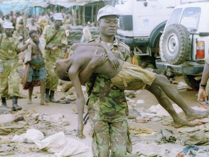 Un casco azul de la ONU lleva en brazos a un refugiado en el campo de Kibeho, al suroeste de Ruanda, en abril de 1995.  