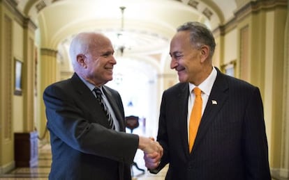 Los senadores John McCain (Izda.) y Charles Schumer se felicitan este jueves.