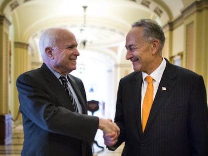 Los senadores John McCain (Izda.) y Charles Schumer se felicitan este jueves.