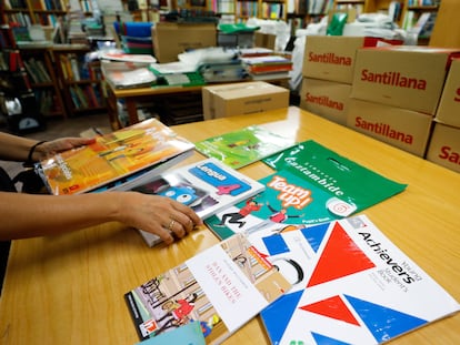 Un docente organiza los libros de texto para el inicio de curso en un centro de Madrid.
