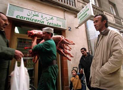 Un hombre pasa delante de una carnicera magreb con unos corderos, en Tetun (Madrid), durante la fiesta de Abraham, fiesta del cordero para los musulmanes.