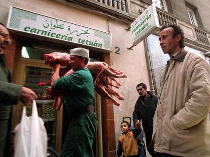Un hombre pasa delante de una carnicería magrebí con unos corderos, en Tetuán (Madrid), durante la fiesta de Abraham, fiesta del cordero para los musulmanes.