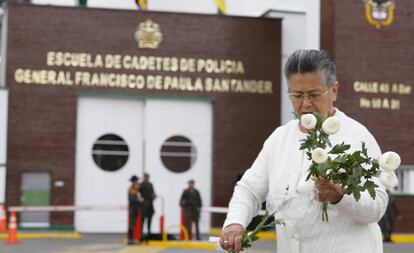 Una mujer coloca flores en memoria de las víctimas del atentado en Bogotá.