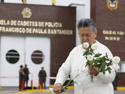 Una mujer coloca flores en memoria de las víctimas del atentado en Bogotá.