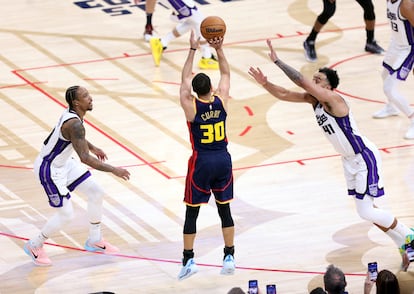 Stephen Curry lanza a canasta un triple, el que supuso el número 4.000 en su carrera, ante a oposición de Demar DeRozan y Trey Lilles.