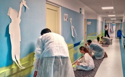 Trabajadores de la  Unidad de Salud Mental Infantil y de Adolescentes del Hospital Virgen del Rocío de Sevilla realizan un mural.