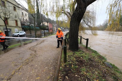 Voluntarios de Protección Civil acordonan la calle Pedret de Girona por el aumento del nivel del río Ter, este miércoles.