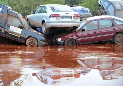 Varios coches amontonados tras las inundaciones producidas por el vertido de residuos de una planta de aluminio.