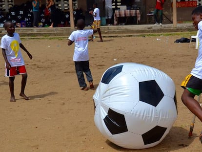 Un nen xuta una pilota inflable al barri de Port Bouët, a Abidjan.