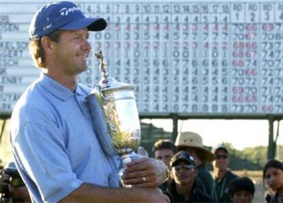 Retief Goosen, con la copa de su segundo Open de EE UU, ante el marcador de Shinnecock Hills.