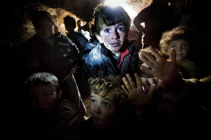 Un grupo de niños se protege en el interior de las cuevas de Idlib de los continuos bombardeos sobre la zona, donde sobreviven sin agua, ni electricidad. Siria, enero de 2013.