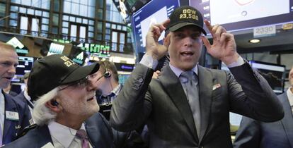 Operadores de la Bolsa de Nueva York con gorras que señalan: "Dow 23.500"