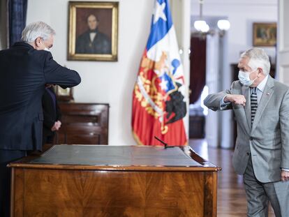 El presidente de Chile, Sebastián Piñera (izquierda), saluda a la distancia a su nuevo ministro de Salud, Enrique París (derecha).