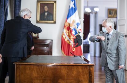 El presidente de Chile, Sebastián Piñera (izquierda), saluda a la distancia a su nuevo ministro de Salud, Enrique París (derecha).