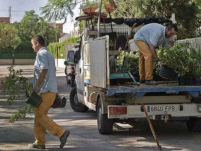 Unos operarios trasladan material de jardinería en el colegio Sanchis Yago para que todo esté a punto para la visita del presidente de la Generalitat.