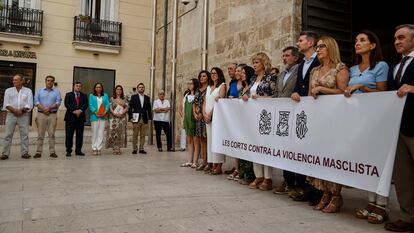 La presidenta de la Corts, Llanos Massó, y el resto de su grupo (al fondo de la imagen), junto a la pancarta de condena por el crimen machista de este domingo en Antalla.