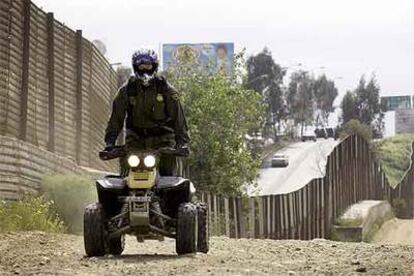Un agente de la policía de fronteras de EE UU patrulla a lo largo de la valla de la frontera mexicana en Tijuana.