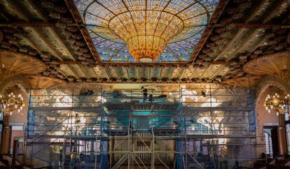 Un operari treballa al Palau de la Música durant la restauració del conjunt escultòric de l'escenari.