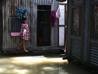 Una niña ante la puerta de su casa, inundada por las fuertes lluvias, en el distrito de Munshiganj, a las afueras de Daca, en julio de 2020