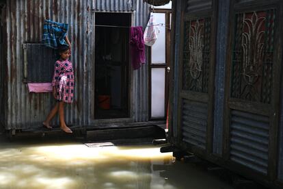 Una niña ante la puerta de su casa, inundada por las fuertes lluvias, en el distrito de Munshiganj, a las afueras de Daca, en julio de 2020