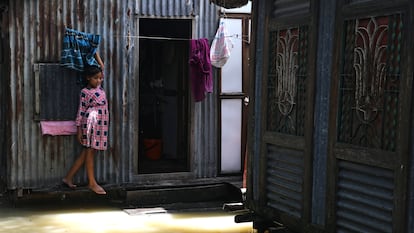 Una niña ante la puerta de su casa, inundada por las fuertes lluvias, en el distrito de Munshiganj, a las afueras de Daca, en julio de 2020