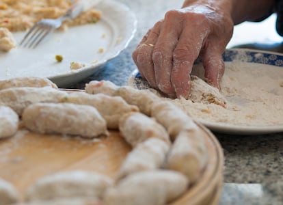 Una mujer prepara croquetas en su casa.