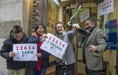 El titular de la administración número 25 de Bilbao 'Lotería los 400 millones', Iñigo Gómez Barrengoa (d) y su familia, celebran los décimos del primer premio.