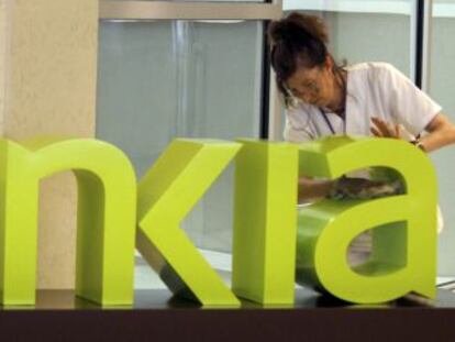 Una operaria limpia el logotipo de Bankia en la sede central de Bancaja