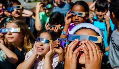 Un grupo de alumnos de un colegio de primaria observa el eclipse mediante unas gafas especiales, en Schiedam, Países Bajos.