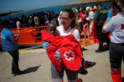 Una miembro de la Cruz Roja acoge a un niño rescatado de una patera en el estrecho de Gibraltar el pasado día 4 de julio.