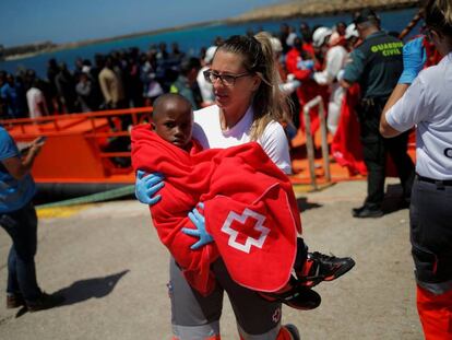 Una miembro de la Cruz Roja acoge a un niño rescatado de una patera en el estrecho de Gibraltar el pasado día 4 de julio.