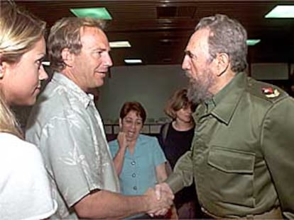 Kevin Costner y Fidel Castro se saludan ayer en presencia de Christine Baumgartner, novia del actor.