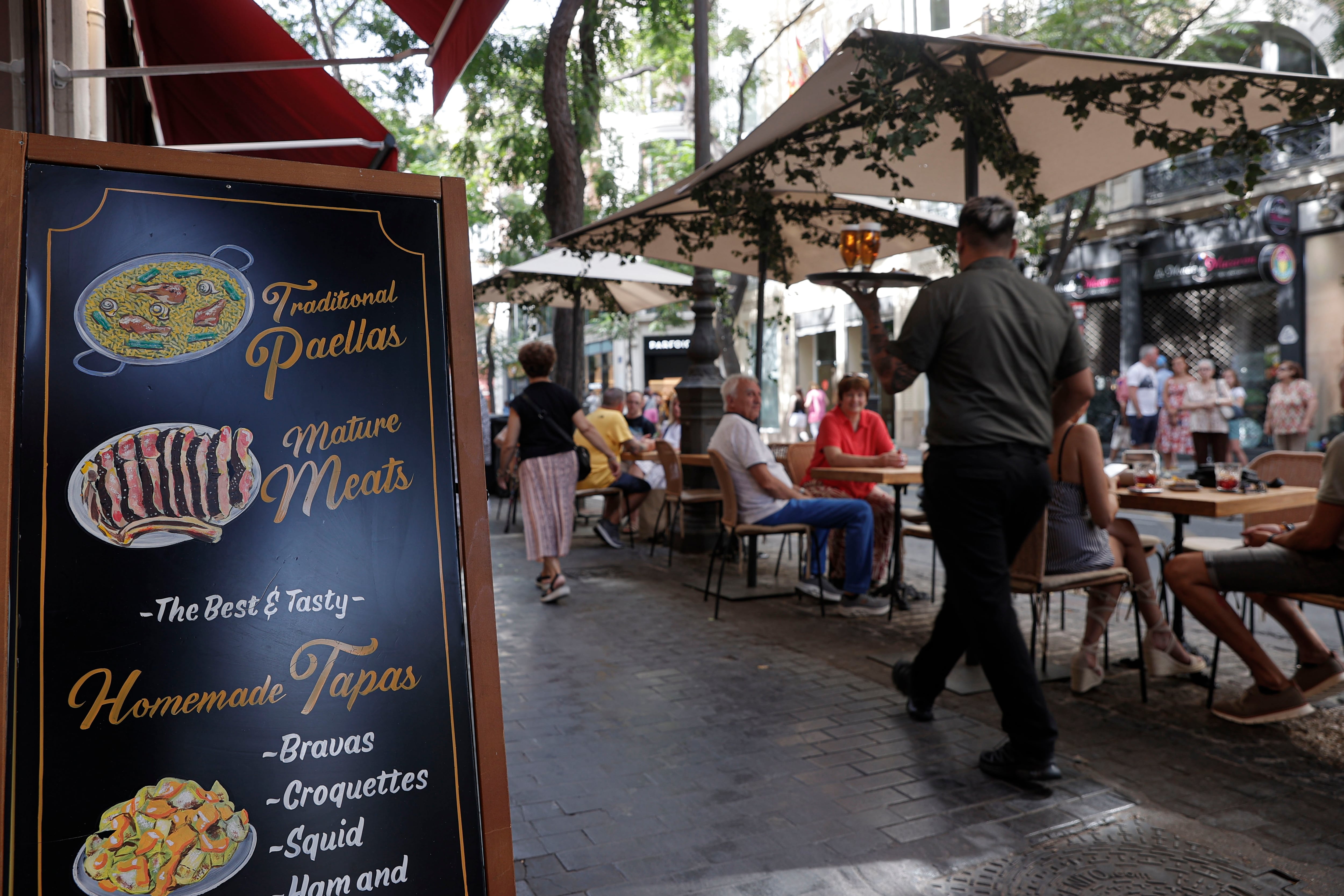 Un camarero lleva unas bebidas a unos clientes en una terraza del centro de Valencia, el 29 de agosto.
