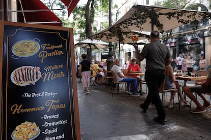 Un camarero lleva unas bebidas a unos clientes en una terraza del centro de Valencia, el 29 de agosto.