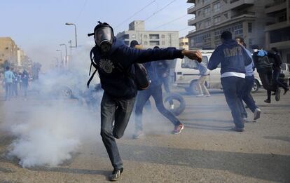 Un partidario del derrocado presidente Mohamed Mursi devuelve una granada de gas lacrimógeno lanzada por la policía durante los enfrentamientos en el distrito de Nasr en El Cairo.