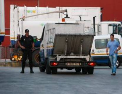 Un policía nacional junto a un camión del servicio de recogida de basuras de Santander tras la huelga indefinida declarada hoy por los trabajadores de la concesionaria del servicio de limpieza de la capital cántabra al no llegar a un acuerdo sobre su situación laboral con la empresa (Ascan-Geaser).