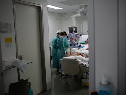 Personal sanitario visita a un enfermo ingresado en la Unidad de Cuidados Intensivos del Hospital de la Santa Creu i Sant Pau.