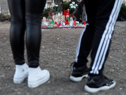 Dos jóvenes frente a un altar en memoria del menor de 15 años fallecido en la calle de Atocha como consecuencia de una pelea entre pandilleros.